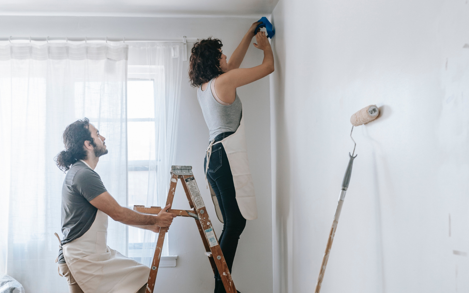 Couple painting a wall in their home