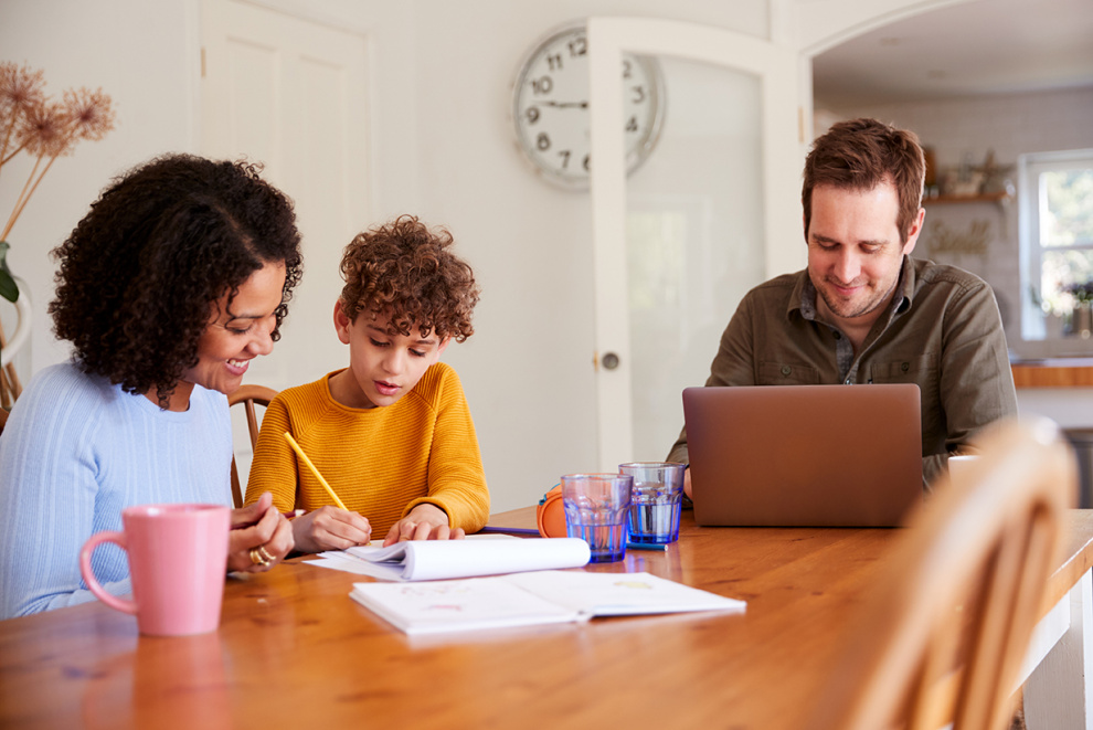 family working and doing homework around table