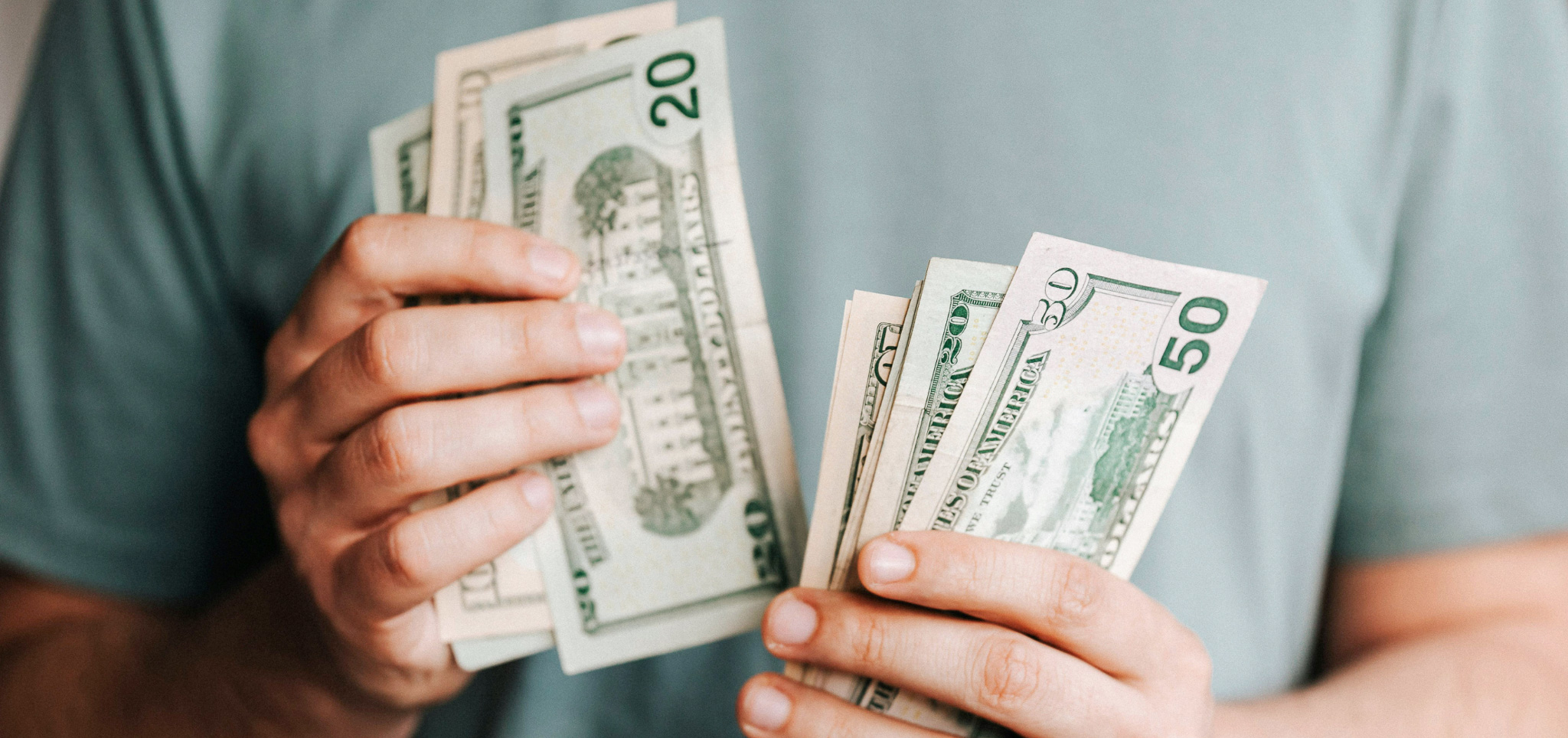 Person holding cash and counting it