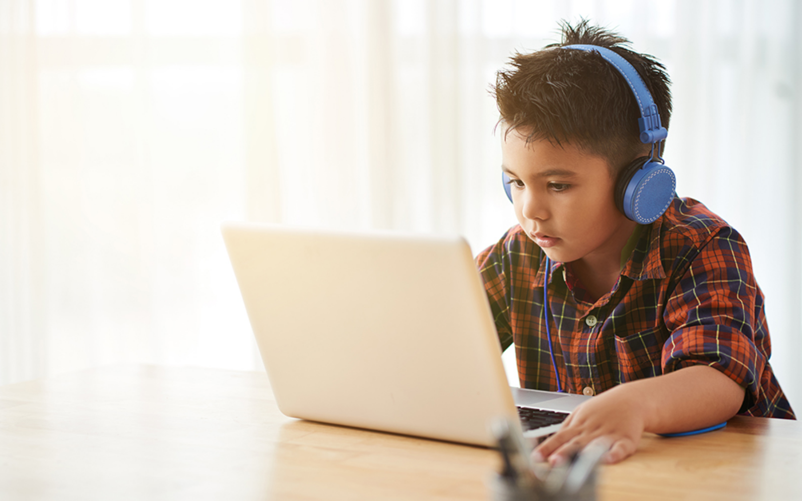 Young boy listening to a video on the computer