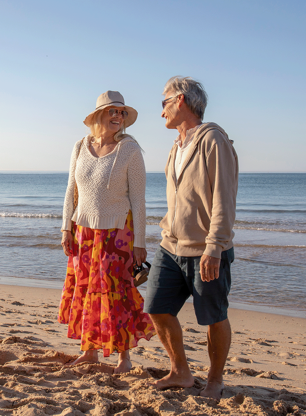 Elderly couple walking on the beach together