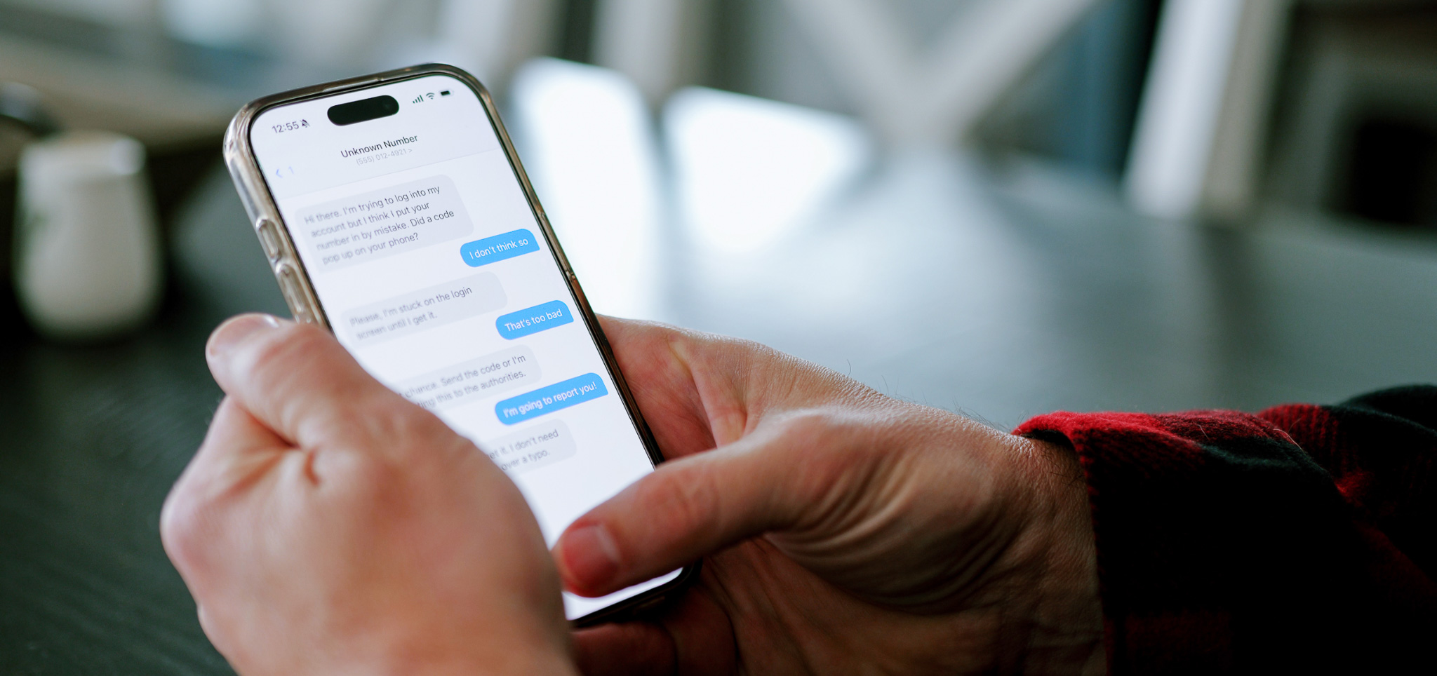 A person on their phone with a text message screen displayed.