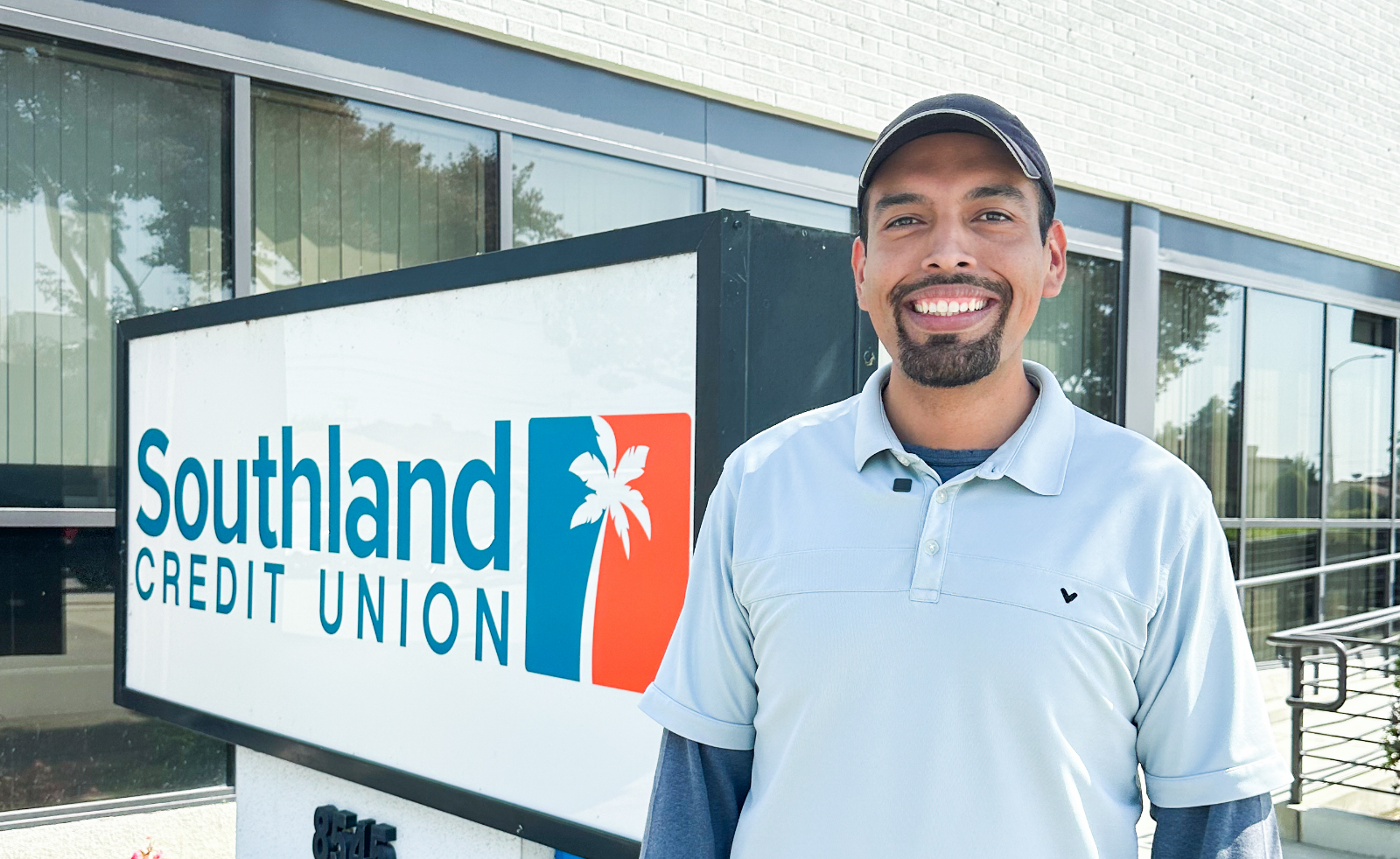 Man smiling and standing outside of a credit union