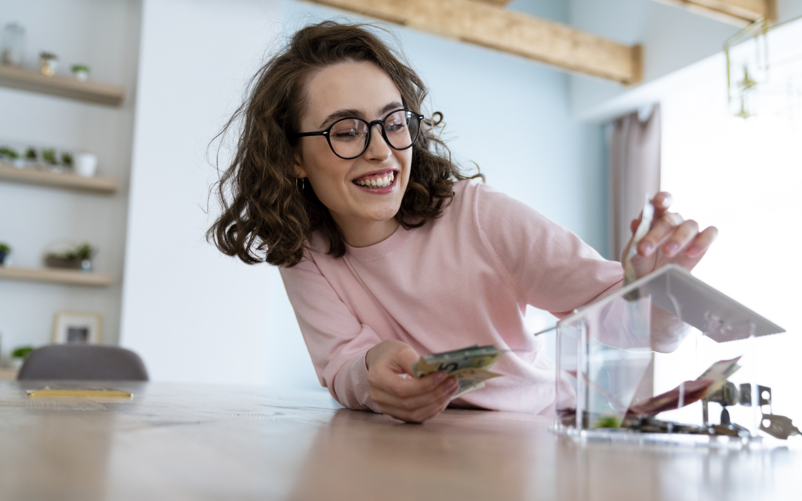 Woman putting money in savings for a house