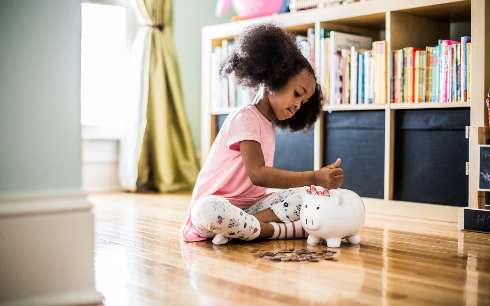 Child putting coins in a piggy bank