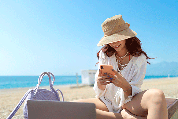 woman at the beach looking at her phone