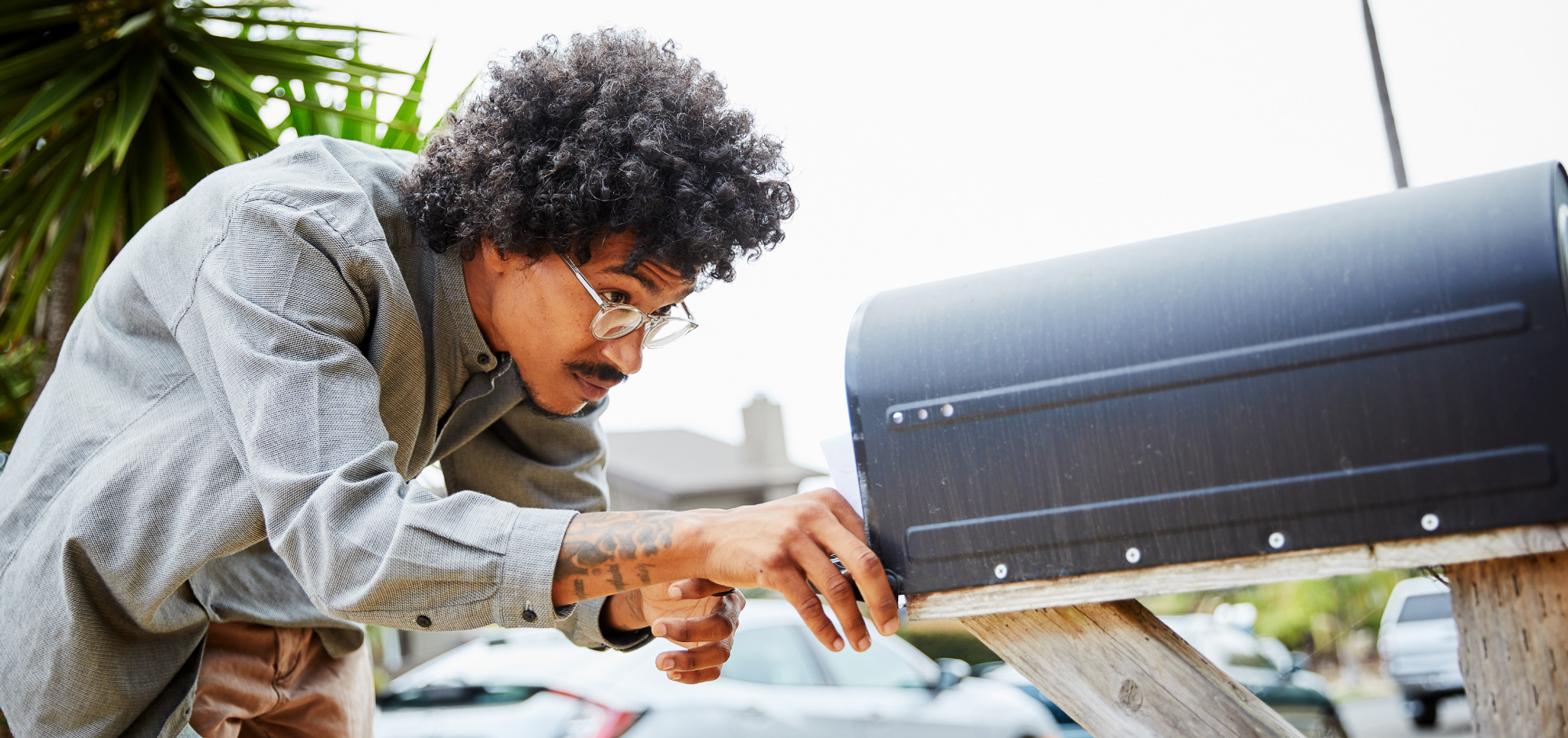 A man putting an object into his mailbox