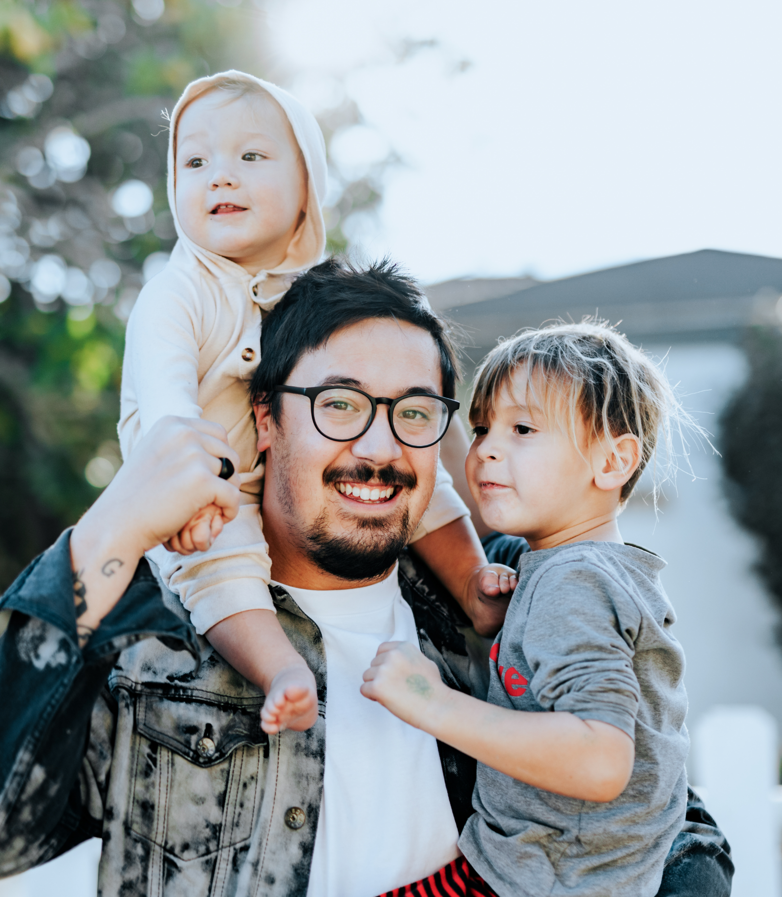 Man holding baby girl and toddler son