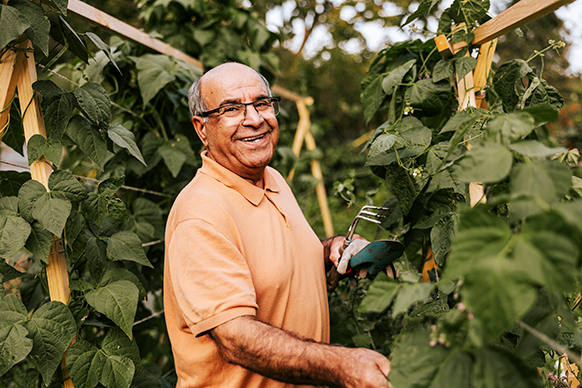 man smiling while working in his garden
